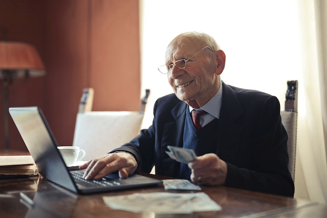 Elderly gentleman working on a laptop, preparing finances